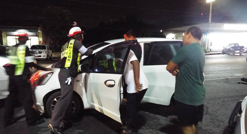 Police inspect Mr Rolfe-Johnson's Bangkok-registered white Honda Jazz following the incident. Photo: Eakkapop Thongtub